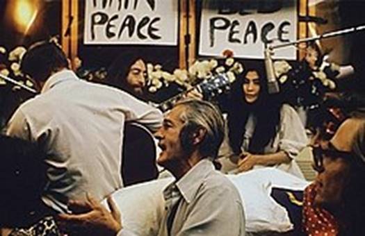 https://upload.wikimedia.org/wikipedia/commons/thumb/2/24/John_Lennon_performing_Give_Peace_a_Chance_1969.jpg/250px-John_Lennon_performing_Give_Peace_a_Chance_1969.jpg